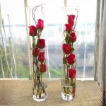 Arranged with 10 red roses and leaves in a long glass -Eco-Blooms